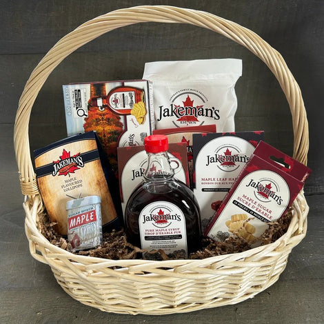 Wicker gift basket with Jakemans maple syrup and snack packages, includes bottle and pouches