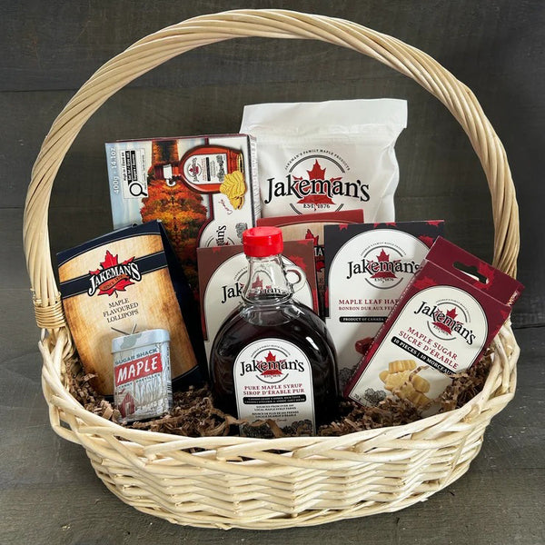 Wicker gift basket with Jakemans maple syrup and snack packages, includes bottle and pouches
