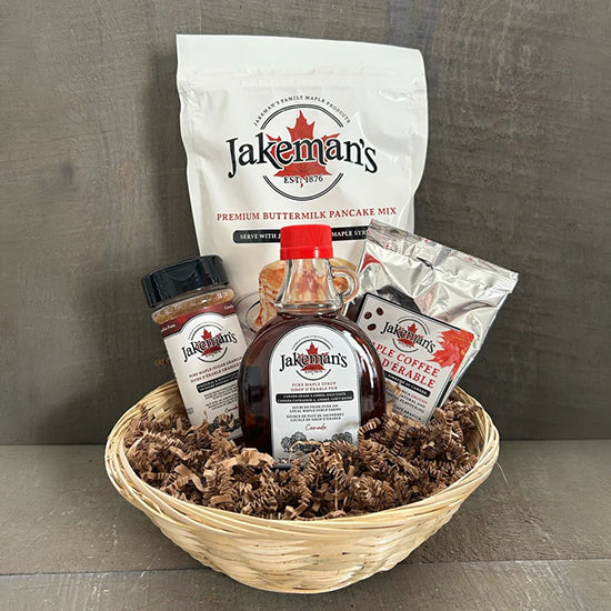 Food gift basket with Jakeman's pancake mix, coffee, and syrup bottles in a wicker tray